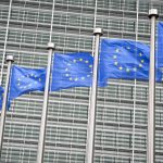 Row of EU European Union flags flying in front of administrative building at the EU headquarters in Brussels, Belgium