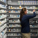 A technician stocks the shelves of the pharmacy at White House Clinic in Berea