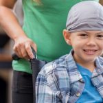 Mother pushes sick little boy in wheelchair