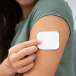 Woman Applying Patch On Her Arm